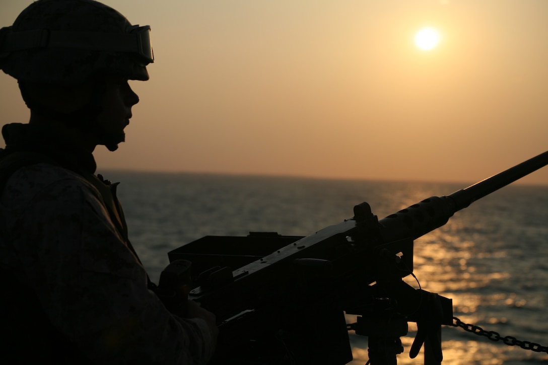 Lance Cpl. Brad D. Fosler, an anti-terrorism force protection security guard with Marine Aviation Logistics Squadron 14, scans the open water for unidentified vessels from the aft deck of the USNS Wright.