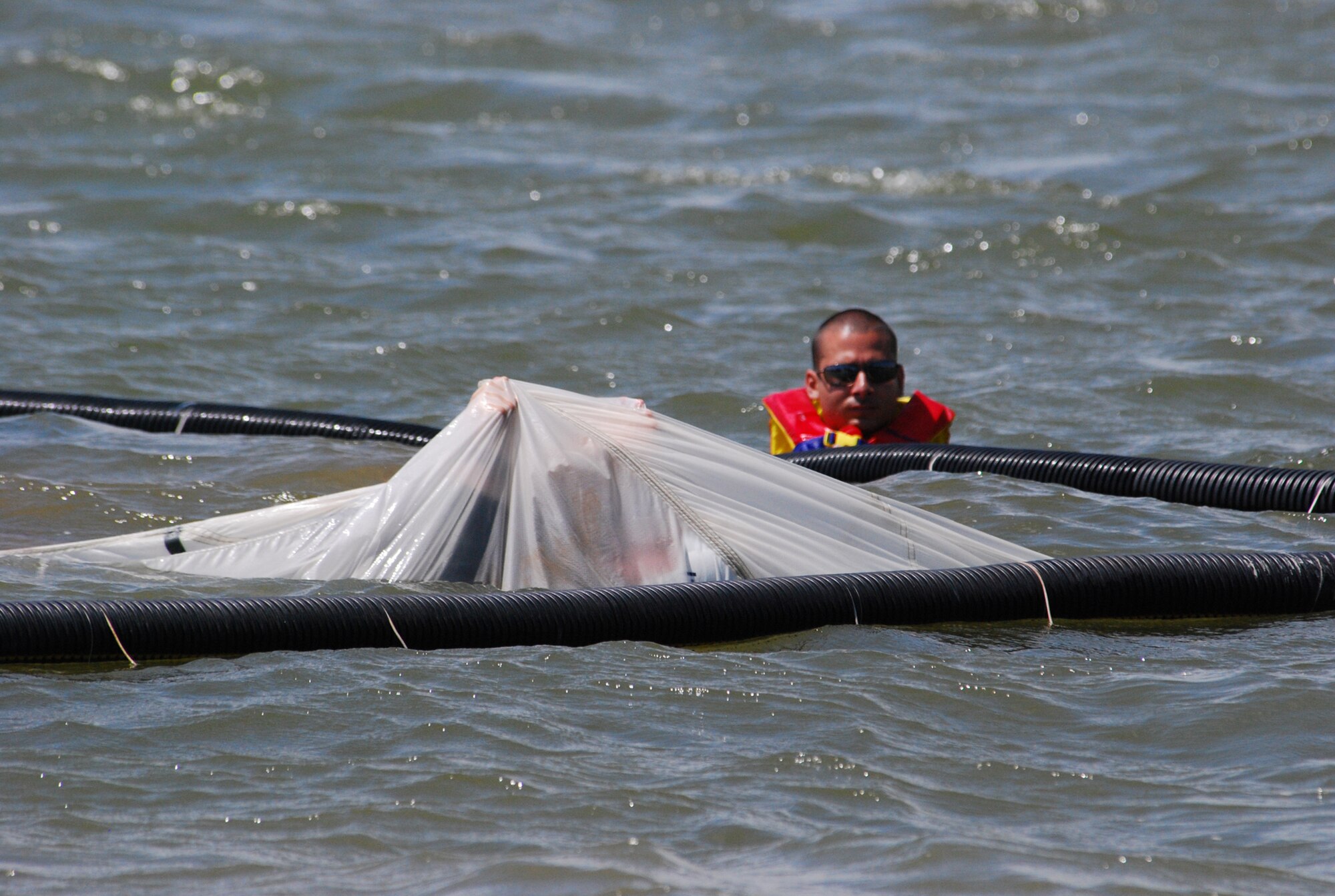 Pilots from the 457th Fighter Squadron recently endured their annual water survival training conducted on Lake Worth in Fort Worth, Texas. Staff Sgt. Travis Roman, 457th Life Support technician, assists the pilots in the correct procedures of navigating thier way from under a parachute. (U.S. Air Force Photo/Tech. Sgt. Julie Briden-Garcia)