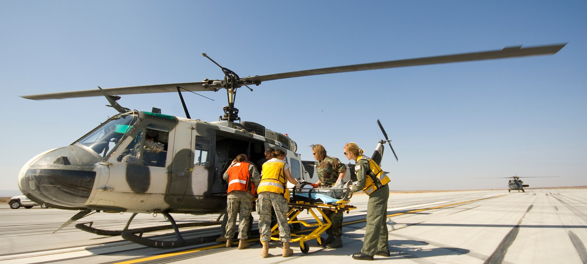 Military medics place an "astronaut" into a UH-1H Iroquois during a simulated space shuttle landing July 26. Human Space Flight requires the base to conduct two exercises a year to ensure its capabilities to support landings still meet NASA’s standards. ( Air Force photo by Mike Cassidy)