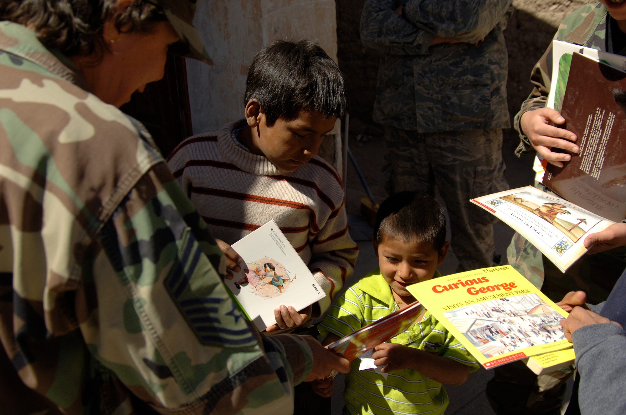 Senior Master Sgt. Teresa Denton-Price, MEDRETE liaison officer for Task Force New Horizons, hands a book to a Peruvian orphan who is waiting for medical attention at a medical mission in Cobadonga, Peru, July 26.  The medical mission is one of nine supporting New Horizons - Peru 2008, a partnered effort between the U.S. and Peru to bring quality-of-life projects to the people of Ayacucho, Peru.  (U.S. Air Force photo/1st Lt. Mary Pekas)