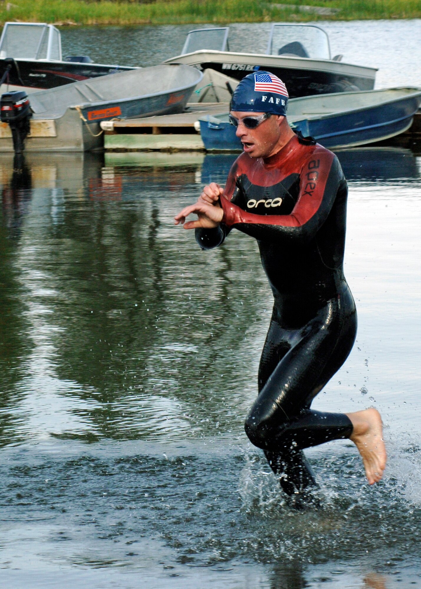 MEDICAL LAKE, Wash. – Tech. Sgt. Michael Bergquist, 242nd Combat Communication Squadron satellite communications technician and currently an augmentee with the 92nd Security Forces Squadron, emerges from Medical Lake as the first to finish the swimming portion of the Clear Lake Triathlon July 26. With a time of 1 hr. 3 min. 57 sec., Sergeant Bergquist beat his first place time last year of 1 hr. 6 min. 48 sec. (U.S. Air Force photo / Airman 1st Class Melissa Barnett)