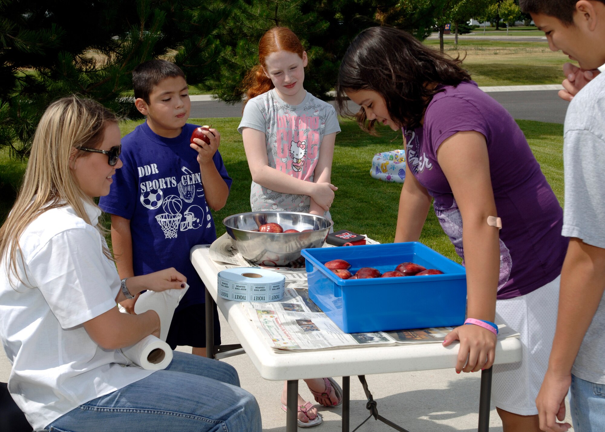 FAIRCHILD AIR FORCE BASE, Wash. – Balfour Beatty Communities resident specialist Christina Schwartz monitors the “bobbing for apples” stand as Sierra Glassburner,11, attempts to catch an apple at the Balfour Beatty Communities grand opening barbeque in front of Fairchild’s housing office here July 26. (U.S. Air Force photo / Airman 1st Class Melissa Barnett)