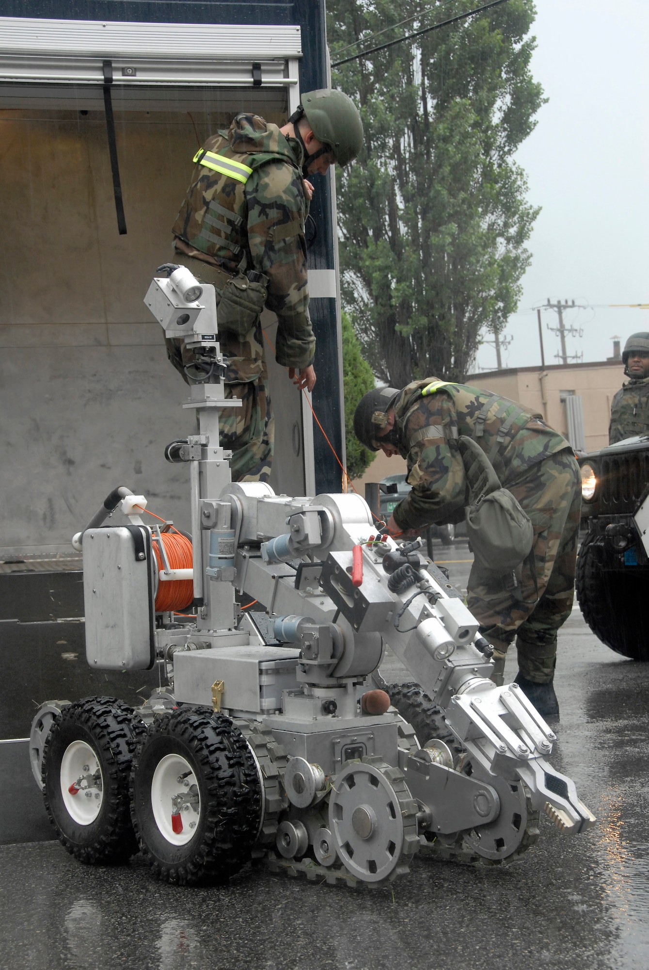 Airman Matthew Morris (left) and Tech. Sgt. Jared Worstell, explosive ordnance disposal Airmen with the 51st Civil Engineer Squadron at Osan Air Base, South Korea, prepare an F6A robot July 24 to remove a suspicious package at the base post office during a base-wide exercise.  The robot is equipped with several television cameras for remote viewing and a dexterous arm for hazardous tasks. (U.S. Air Force photo/Staff Sgt. Lakisha Croley)