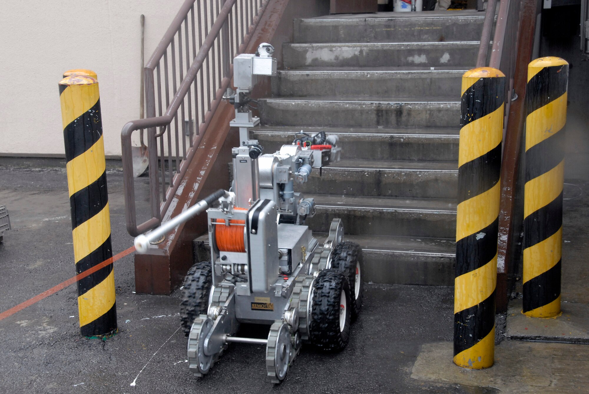An F6A robot, used by explosive ordnance disposal Airmen with the 51st Civil Engineer Squadron at Osan Air Base, South Korea, prepares to remove a suspicious package at the base post office during a base wide exercise July 24. The robot is equipped with several television cameras for remote viewing and a dexterous arm for hazardous tasks. (U.S. Air Force photo/Staff Sgt. Lakisha Croley)