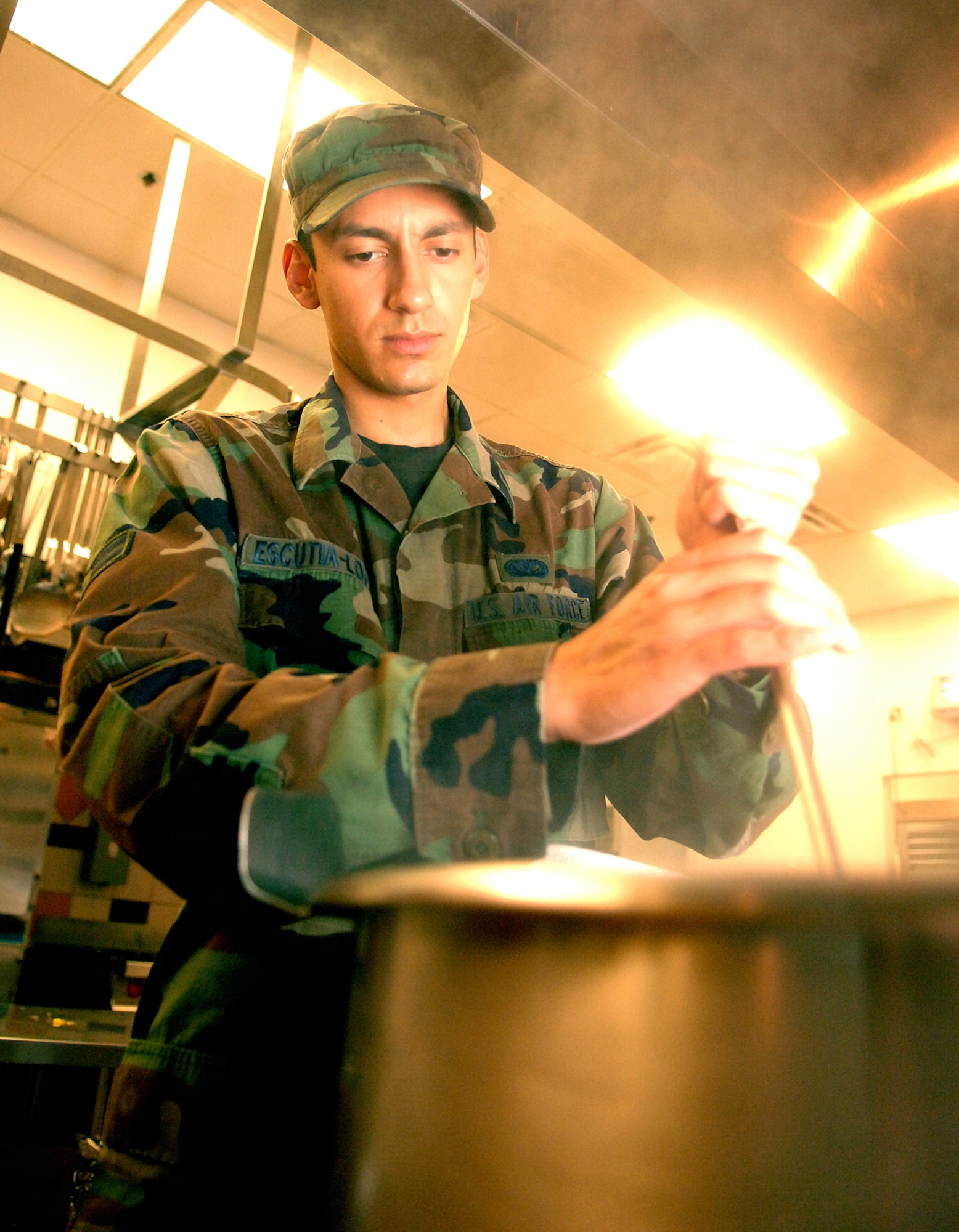 Airman 1st Class David Escutia-Lopez,  49th Force Support Squadron, stirs a hot pot of pork shop suey in preparation for lunch in the Shifting Sands Dining Facility at Holloman Air Force Base, N.M., July 11. Airmen who work in the DFAC have the responsibility of cooking food, running a grill on the front line and serving food to Airman three times a day. (U.S. Air Force photo/Airman Sondra M. Wieseler)