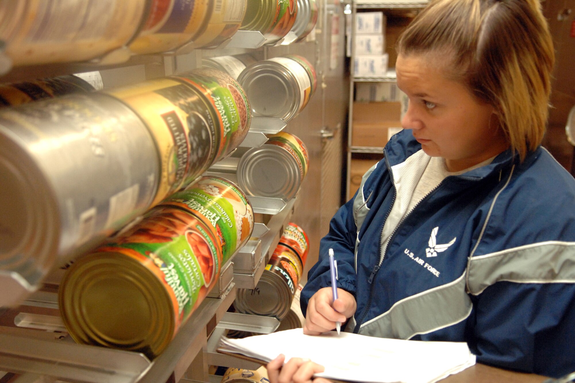 Airman 1st Class Amanda Morgan, 49th Force Support Squadron, takes inventory of canned items in the store room of the Shifting Sands Dining Facility at Holloman Air Force Base, N.M., July 11. The Airmen who work in the store room are responsible for keeping track of the amount of food they have and ordering more food when needed. (U.S. Air Force photo/Airman Sondra M. Wieseler)