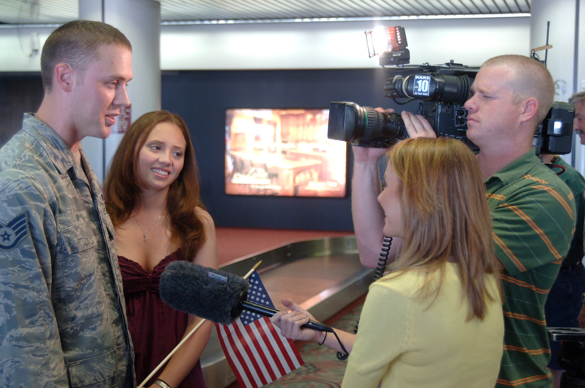 MCCONNELL AIR FORCE BASE, Kan.  -- Staff Sgt. Scott Ury and wife, Stacey, talk to media representatives from KAKE-TV concerning his deployment in Iraq at the Wichita Mid-Continent Airport, July 27. (Photo by Airman 1st Class Jessica Lockoski)