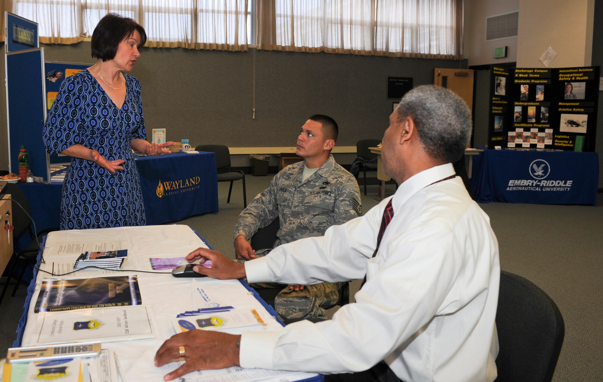 ELMENDORF AIR FORCE BASE, Alaska -- Monique Holland discusses degree options with Tech. Sgt. Roger Davila, 611th Air Support Squadron, at the Eduaction Center Fair July 23. Ms. Holland is an academic advisor for Wayland Baptist University. (U.S. Air Force photo/Airman 1st Class Tinese Treadwell)
