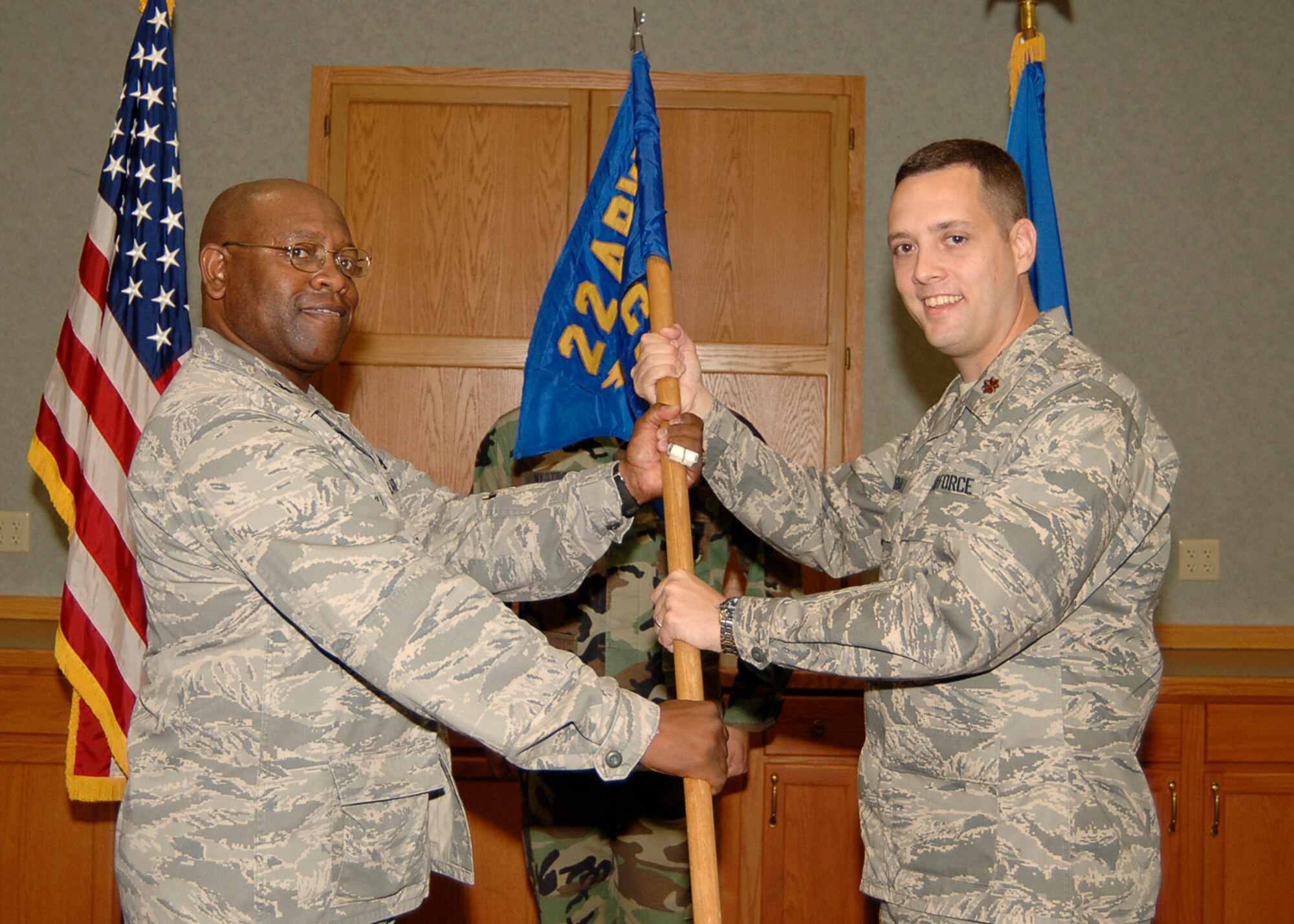 MCCONNELL AIR FORCE BASE, Kan. -- Col. Michael Dillard, left, 22nd Maintenance Group commander, hands the 22nd Comptroller Squadron guidon to Maj. Edward Marshall giving him command of 22nd CPTS during a change of command ceremony, July 28. (Photo by Airman 1st Class Maria Ruiz)