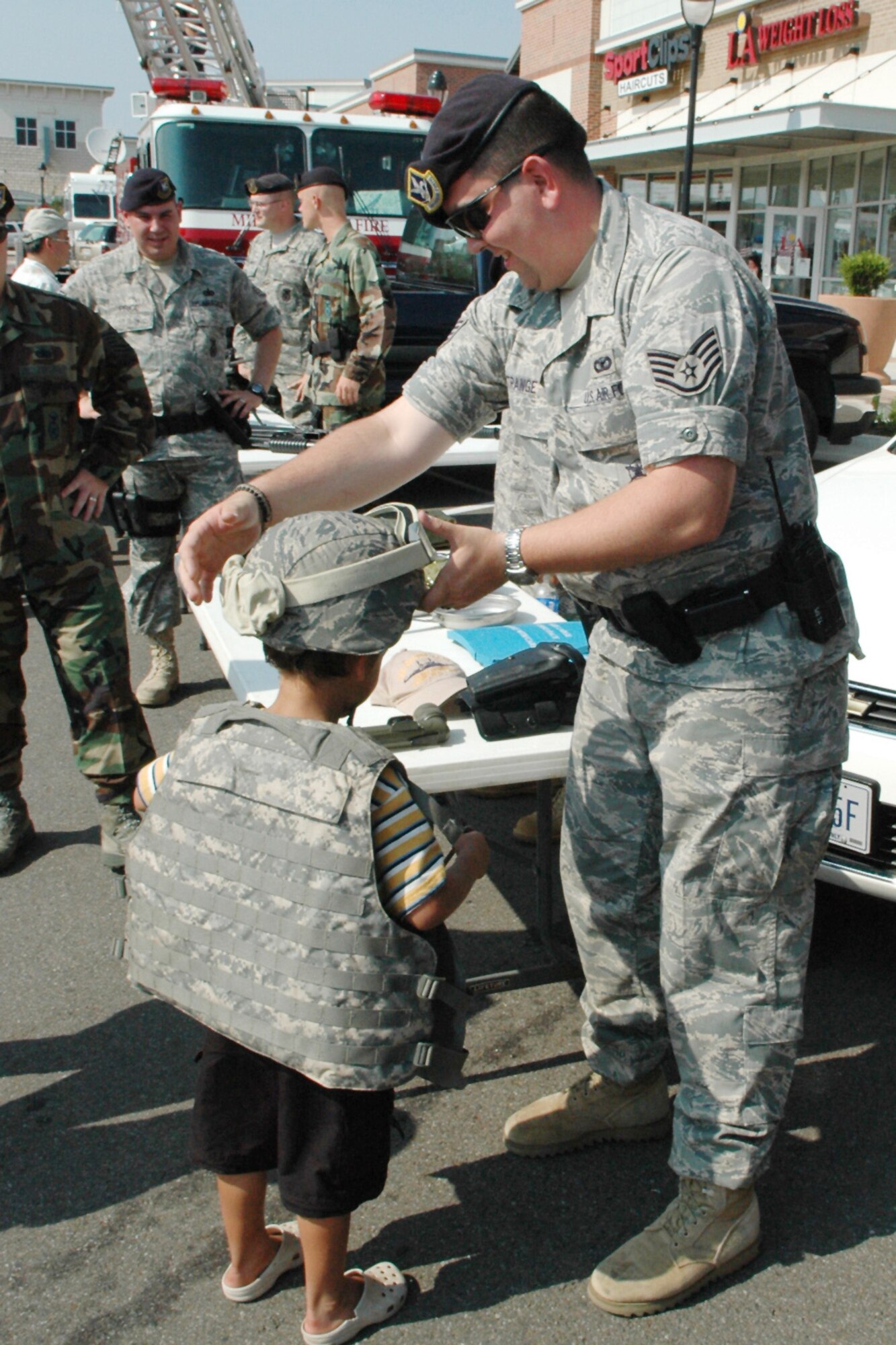 Staff Sgt. Patrick Strange, 72nd Security Forces Squadron, helps a youngster don a flack vest and helmet during a special Midwest City community pride celebration July 23. Midwest City and Tinker Air Force Base were featured by KOCO TV-5 as part of its summer “On the Road” show spotlighting select communities in the state. In addition to the Security Forces, the 3rd Combat Communications Group also provided a combat display for the event. Earlier in the day, KOCO TV-5 visited the Oklahoma City Air Logistics Center, the 552nd Air Control Wing and Strategic Communications Wing One. (U.S. Air Force photo)