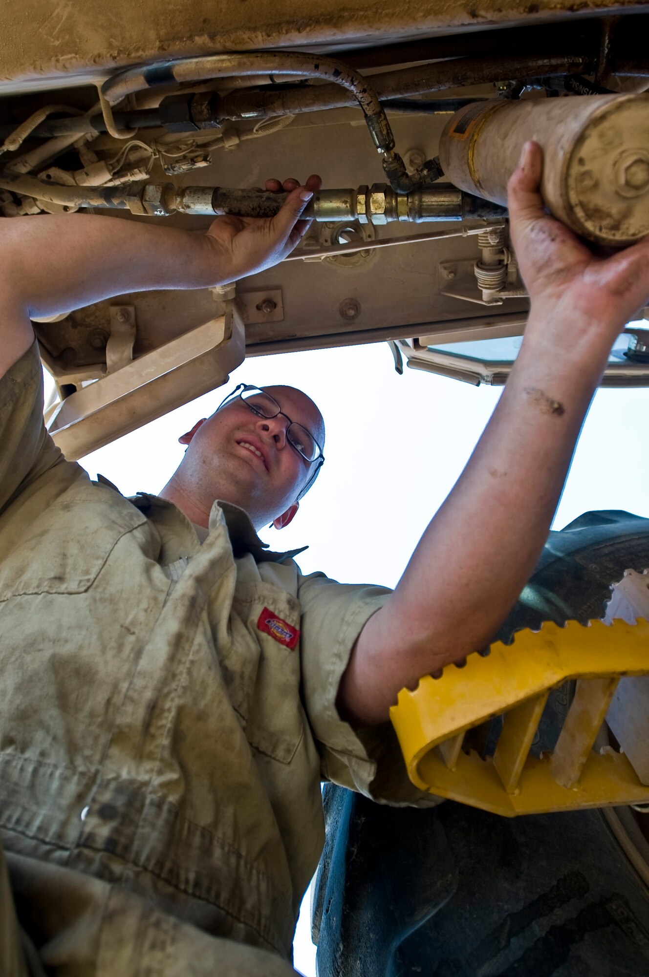ALI BASE, Iraq -- Senior Airman Alex Bissias, 407th Expeditionary Logistics Readiness Squadron vehicle maintainer, performs maintenance on a John Deer Grader's hydraulic cylinder July 30, 2008. The vehicle maintenance shop here maintains all Air Force vehicle assets, more than 300 vehicles and other heavy machinery. Airman Bissias is deployed from Royal Air Force Mildenhall, England. (U.S. Air Force photo/Airman 1st Class Christopher Griffin)