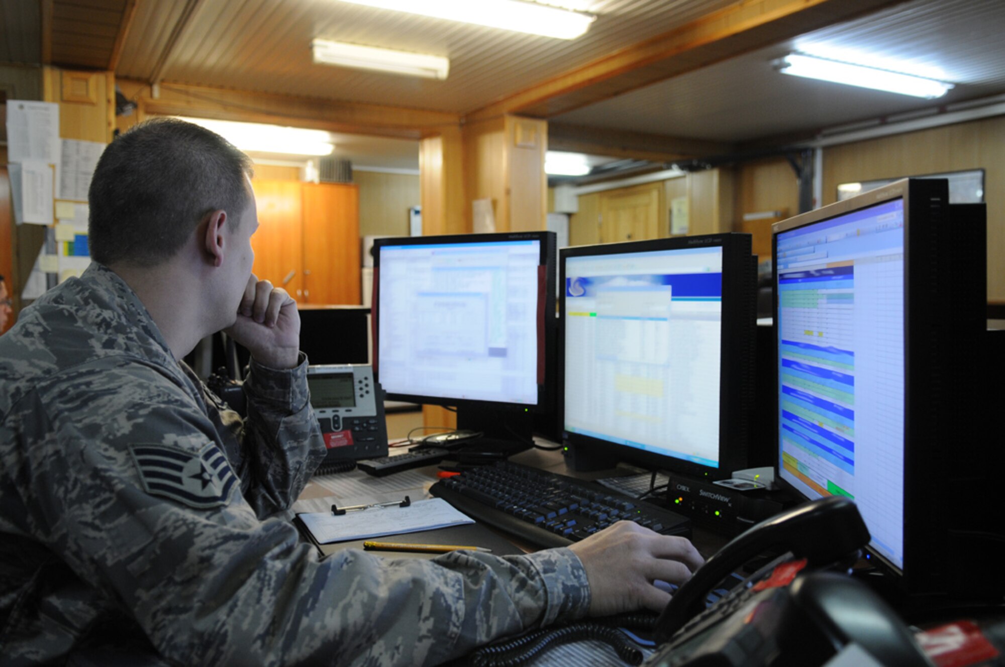 MANAS AIR BASE, KYRGYZ REPUBLIC -- Staff Sgt. Richard Youngblood, 376th Air Expeditionary Wing Command Post controller, monitors and updates flight information on multiple computers here July 28. The Manas Air Base command post serves as the wing's nerve center. Its controllers are responsible for monitoring and tracking emergencies as well as all aircraft sorties taking off and landing at the Kyrgyz Republic air base. (U.S. Air Force photo / Airman First Class Ruth Holcomb)