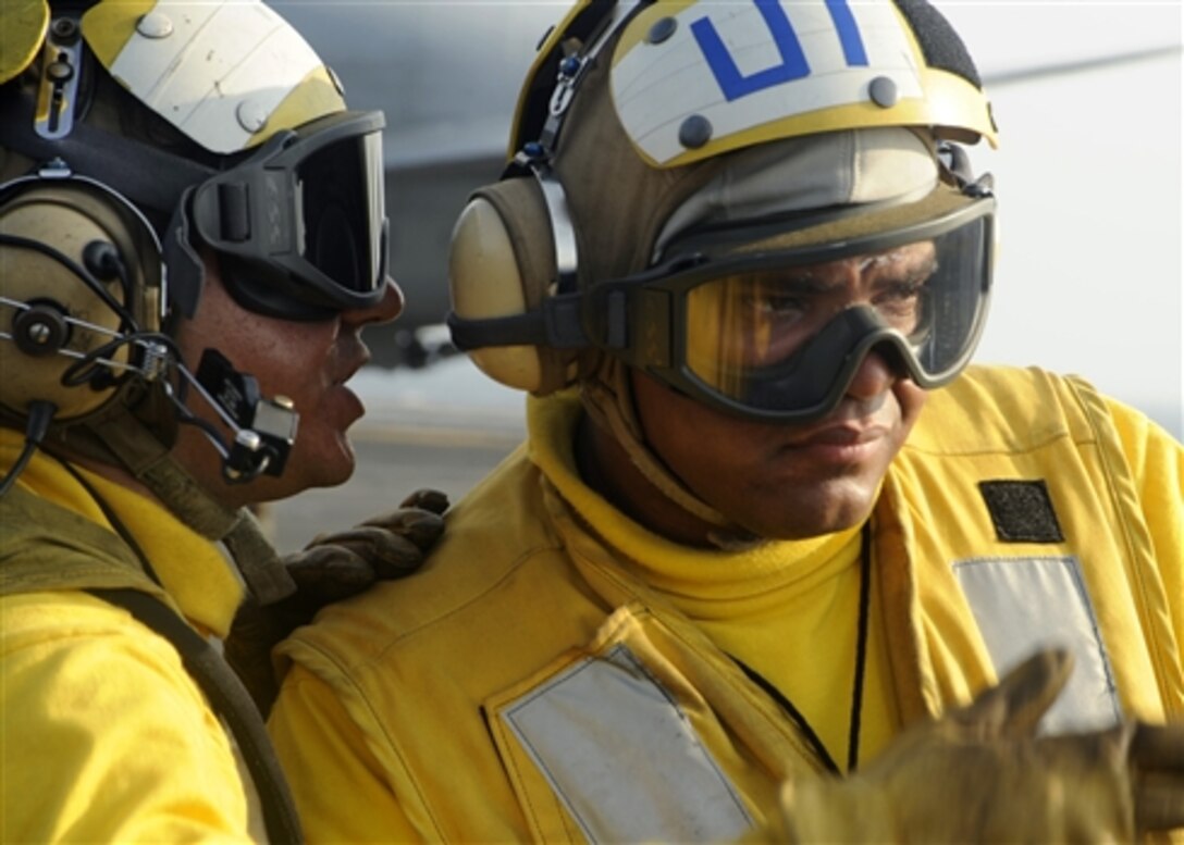 Seamen communicate on the flight deck of the aircraft carrier Theodore Roosevelt while directing aircraft to position for launch in the middle of the Atlantic Ocean, July 28, 2008. Theodore Roosevelt Carrier Strike Group is participating in Joint Task Force Exercise "Operation Brimstone" off the Atlantic Coast. The seamen are aviation boatswain's mates (handling).

