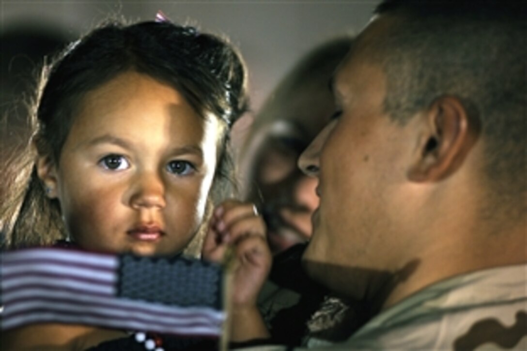U.S. Air Force Staff Sgt. Anthony Cathcart holds his daughter after arriving at Ellsworth Air Force Base, S.D., July 29, 2008. Cathcart is one of 309 airmen returning home from a six-month deployment to Southwest Asia and is an aerospace maintenance journeyman assigned to the 28th Aircraft Maintenance Squadron. 