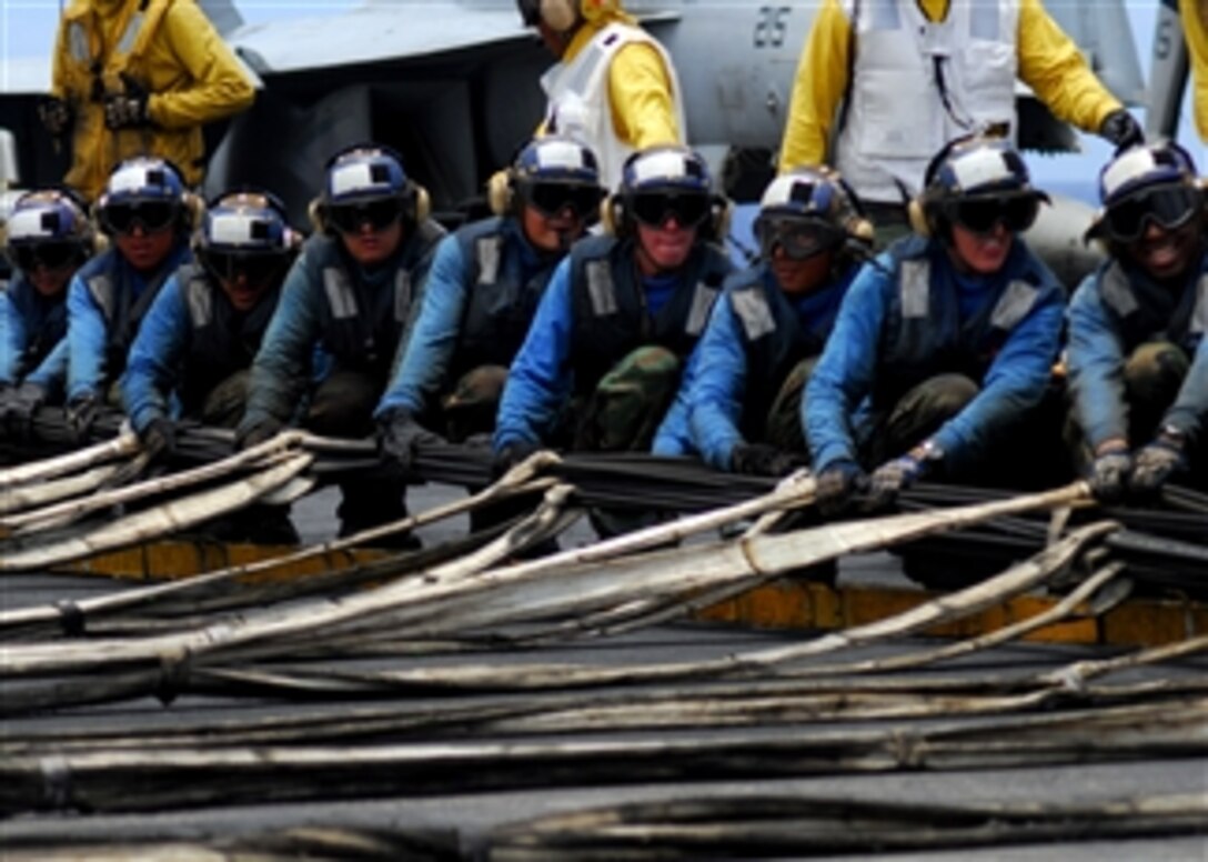 U.S. Navy sailors from the air department prepare to raise an aircraft barricade aboard the USS Kitty Hawk (CV 63) during flight deck drills while underway in the Pacific Ocean on July 23, 2008.  The ship is participating in Rim of the Pacific 2008, a biennial exercise hosted by U.S. Pacific Fleet that brings together military forces from Australia, Canada, Chile, Peru, Japan, the Netherlands, Singapore, the United Kingdom and the Republic of Korea.  