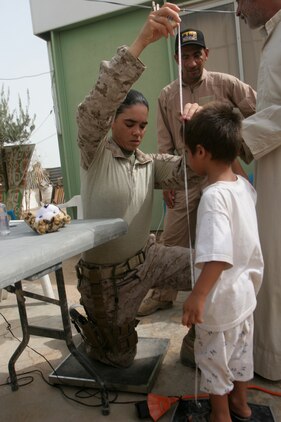 TRAILER TOWN, Iraq (July 31, 2008) – Navy Petty Officer 1st Class Stephanie L. Minix, Headquarters and Service Company, 1st Supply Battalion (-) (REINFORCED), 1st Marine Logistics Group, checks the height of an Iraqi child at the triage section of a cooperative medical engagement here, July 31. The purpose of the CME was to increase the quality of life for residents in Trailer Town and to further develop and improve relationships with the locals. Chest pain, abdominal pain, headache and sore throat were some of the most common complaints at the engagement.  Iraqi Police, along with Marines with Bravo Battery, 2nd LAAD Bn., provided security for the mission. Sixty-five Iraqis were seen during the visit, 55 percent of those patients were pediatric, 35 percent were adult males and 10 percent were adult females. This engagement was a continuation of a CME in Kabani which helped more than 130 Iraqis. In all, approximately 200 Iraqis were treated. (Photo by Lance Cpl. Robert C. Medina)