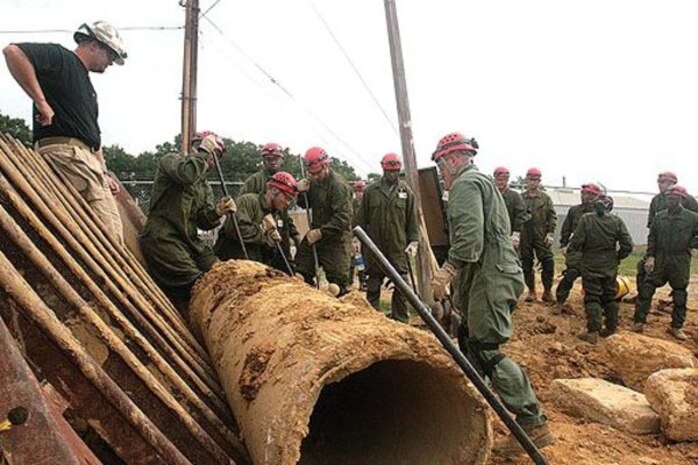 Marines from a Marine Security Guard training unit attending the Chemical Biological Incident Response Force Basic Course, II Marine Expeditionary Force, move a large pipe obstructing an entrance to a simulated collapsed structure, July 23. The Marines were given only pry bars, shovels and two stretchers to search for and rescue the simulated casualties in the collapsed structure. ::r::::n::