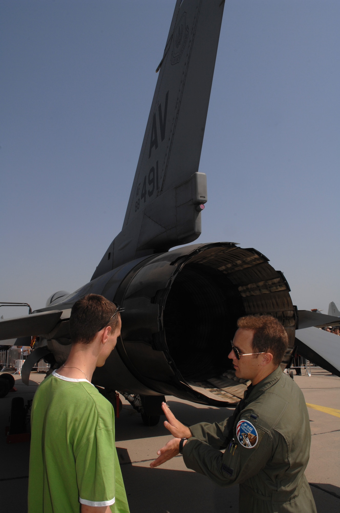 BERLIN, Germany - 1st Lt. Garrett Chandler, F-16 pilot from the 510th Fighter Squadron at Aviano Air Base, Italy, explains how the F-16 Fighting Falcon speed brakes work to an air show guest during the 2008 Berlin Air Show.  U.S. participation in the Berlin Air Show enhances the U.S.-German military-to-military relationship, supports our security cooperation strategic direction efforts, and fosters good relations and better understanding among nations. (U.S. Air Force photo by Tech. Sgt. Corey Clements) (released)