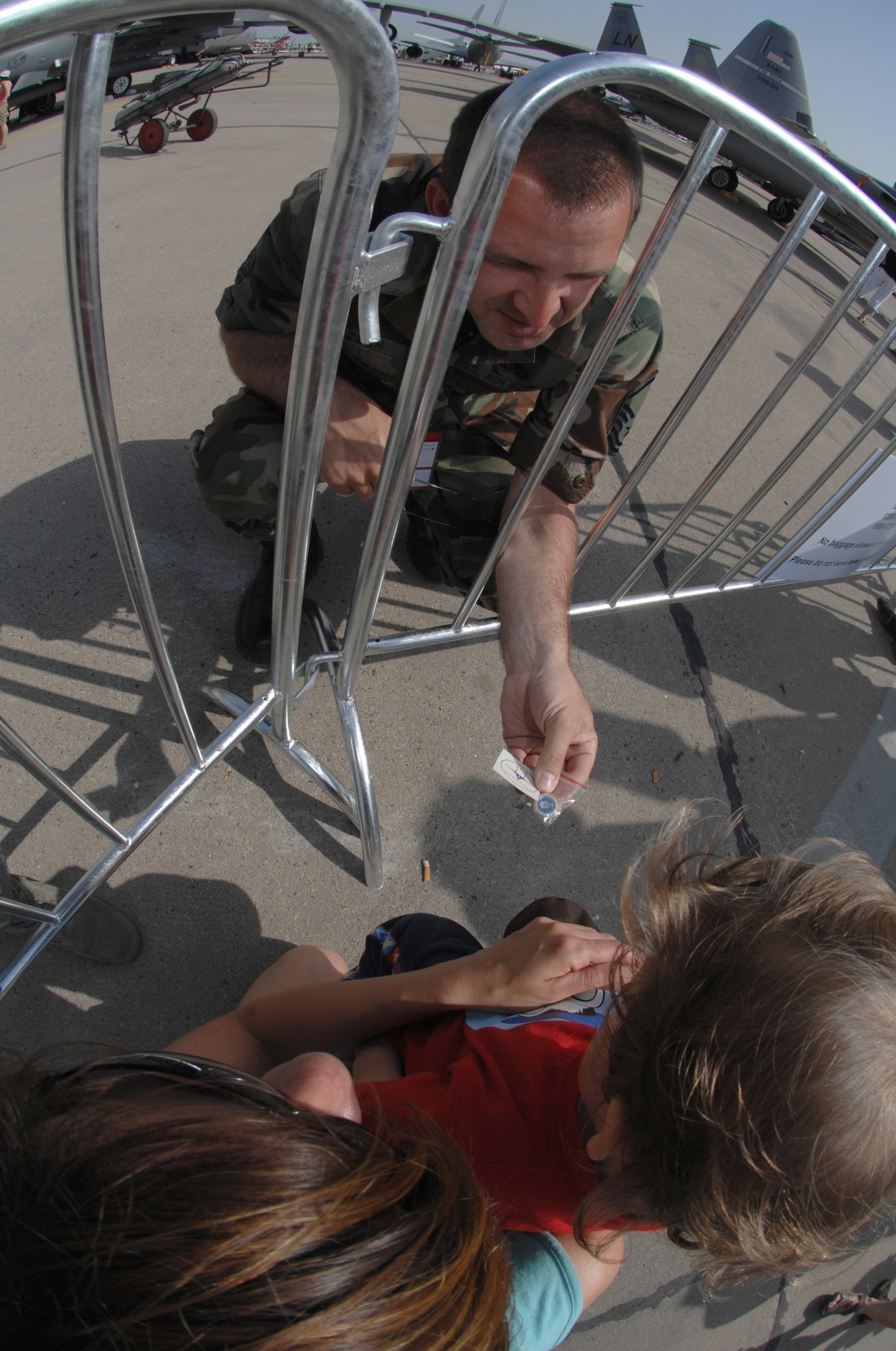 BERLIN, Germany - Master Sgt. John Zilch from the 493rd Aircraft Maintenance Unit at Royal Air Force Lakenheath gives an F-15 Eagle tattoo sticker to a small child while they wait to tour the U.S. corral during the 2008 Berlin Air Show.  U.S. participation in the Berlin Air Show enhances the U.S.-German military-to-military relationship, supports our security cooperation strategic direction efforts, and fosters good relations and better understanding among nations. (U.S. Air Force photo by Tech. Sgt. Corey Clements) (released)