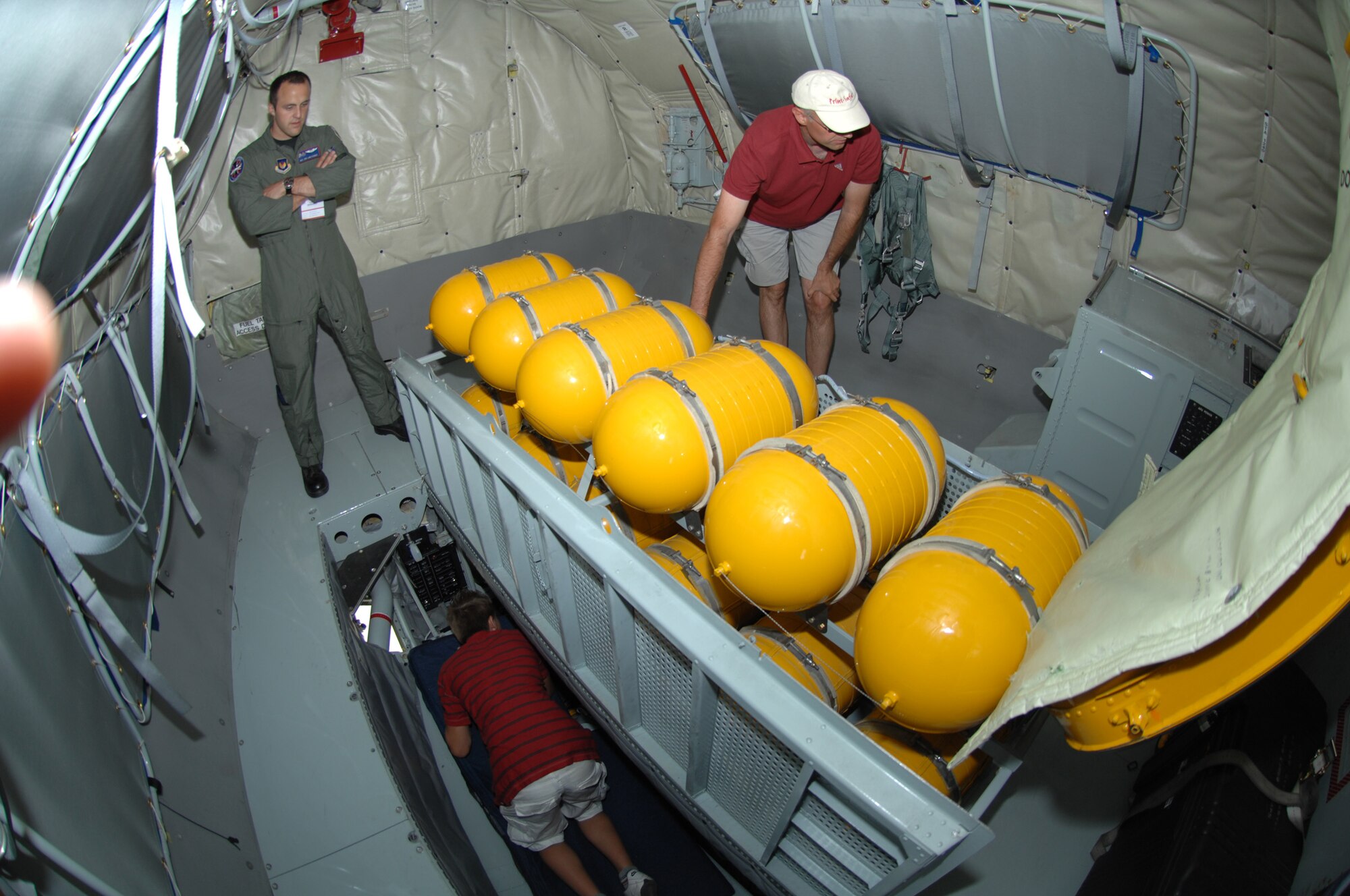 BERLIN, Germany - Airman 1st Class Jon LeMessurier, a boom operator from the 351st Air Refueling Squadron at Royal Air Force Mildenhall (left) watches air show guests while they tour the boom pod of a KC-135R Stratotanker during the 2008 Berlin Air Show.  U.S. participation in the Berlin Air Show enhances the U.S.-German military-to-military relationship, supports our security cooperation strategic direction efforts, and fosters good relations and better understanding among nations. (U.S. Air Force photo by Tech. Sgt. Corey Clements) (released)