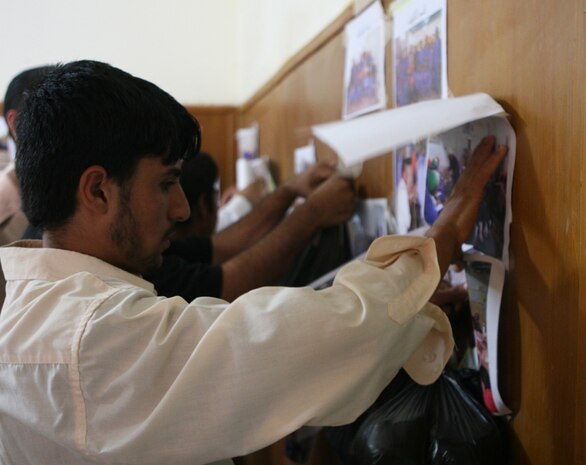 A student retrieves photographs taken of himself and classmates at the Vocational Training Center in Husaybah, Iraq, June 1. The students spent three months learning a variety of skills such welding, plumbing and floor tiling.