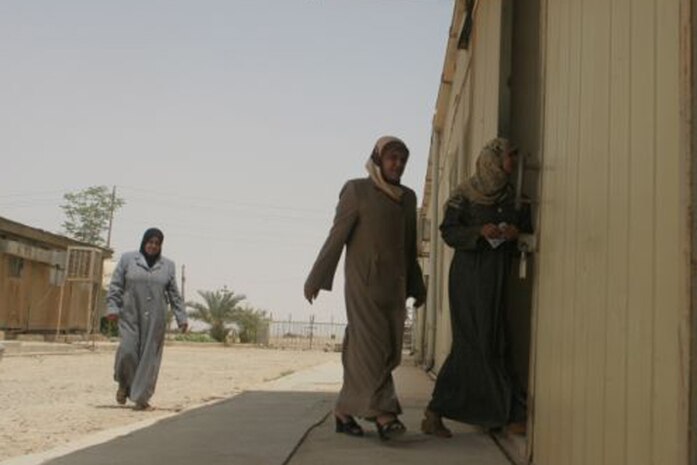Two Iraqi women enter into the textile factory in Anah, Iraq, where they work June 1. The women in the factory met with the Iraqi Womens Engagement team, Detachment 1, Civil Affairs Team 5, 2nd Battalion, 11th Marine Regiment, Regimental Combat Team 5, to talk about what they needed in their community and at their job. The women are given the opportunity to voice their opinion as to what they would like see done in the city.
