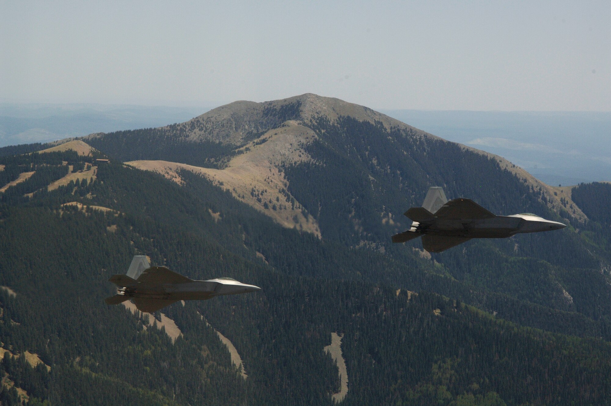 Col. Jeff Harrigian, 49th Fighter Wing commander, and Lt. Col. Mike Hernandez, 7th Fighter Squadron commander, fly a pair of F-22A Raptors past Sierra Blanca mountain, on the way to Holloman Air Force Base, N.M., June 2. The jets are the first two Holloman-tailed F-22's to arrive on base. (U.S. Air Force Photo/ Senior Airman Russell Scalf)