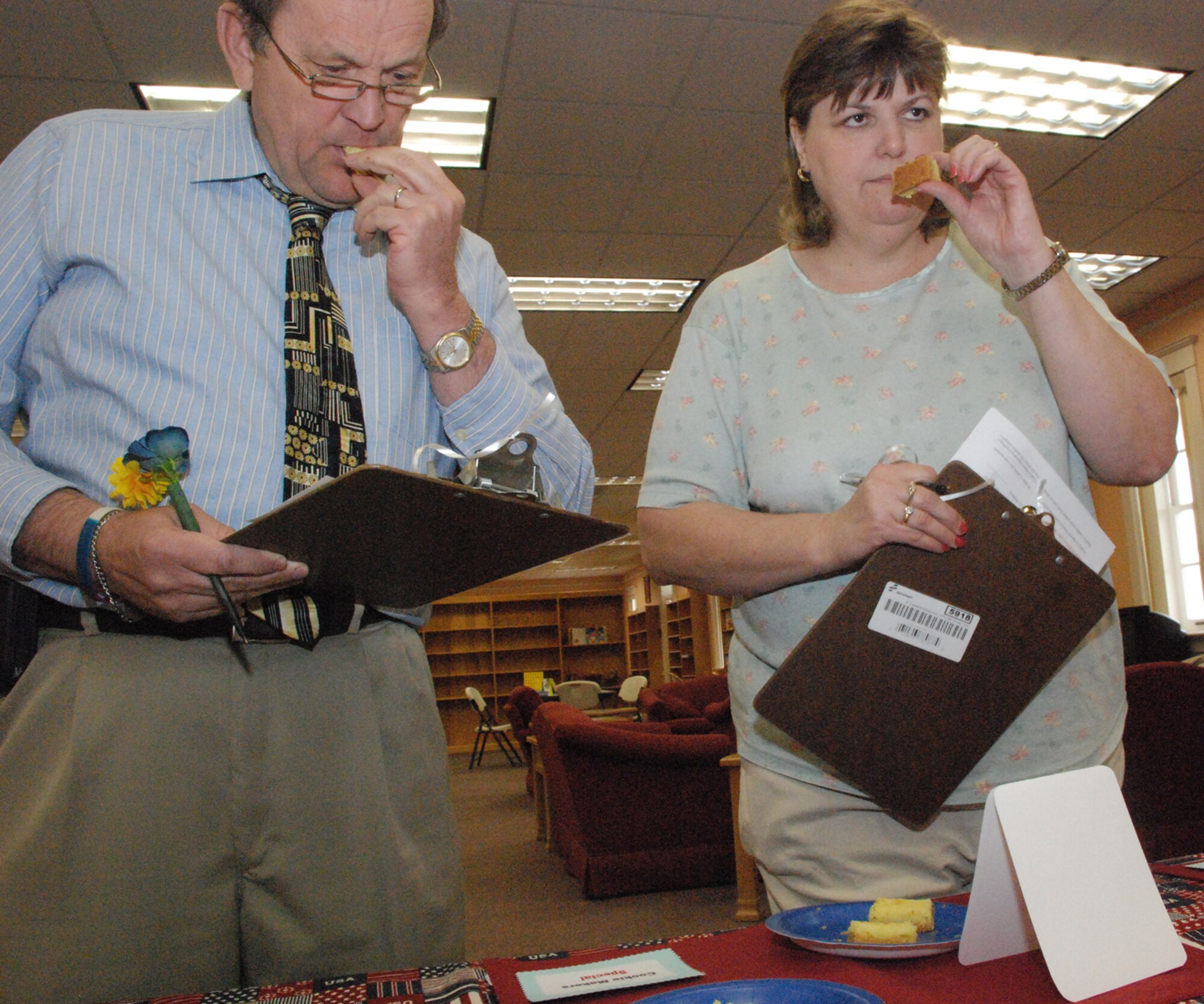 Randy Shircel, 90th Force Support Squadron deputy commander, and Ginny Newbold, Warren's Defense Commissary Agency store administrator, sample the cream cheese cookie bar entry made by Master Sgt. Chanicke Floyd, 90th FSS, during the Air Force Colossal Cookie Challenge at the communibrary May 16. The cream cheese bar cookies won the Cookie Maker's Special category. Other winners were Laura Foster for her Grandma Laura's cookies in the Healthy Cookies category and Chelsea Redmond for her Sticks in Mud cookies in the No Bake category. The winners will compete next at Air Force Space Command for a chance to compete at the Air Force level. Some cookies from the contest were shipped to military members overseas (Photo by 2nd Lt. Lisa Meiman).