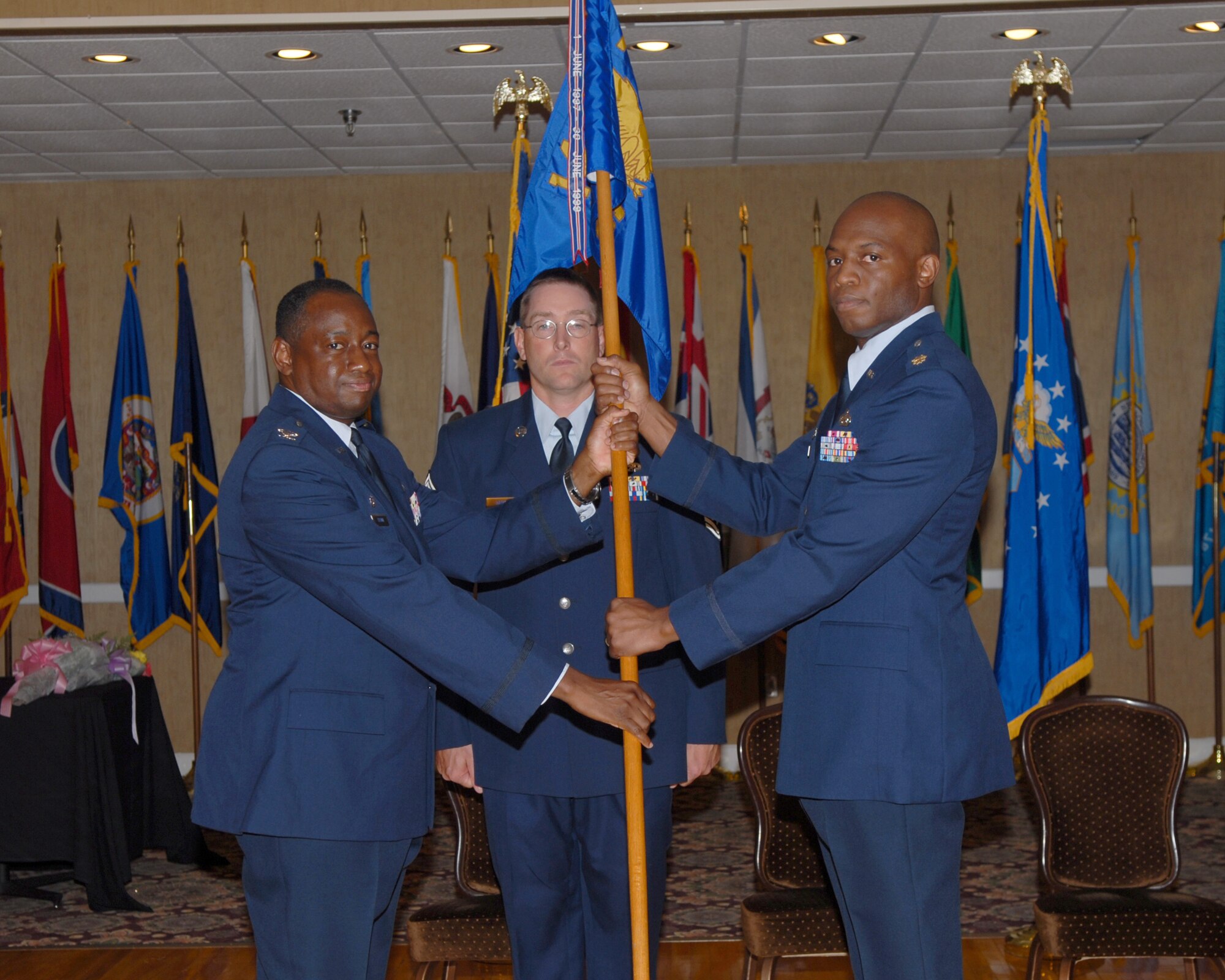 Colonel Mark Brown, 14th Mission Support Group commander, passes the guideon to Maj. Leo Lawson, 14th Communications Squadron commander, in his change of command ceremony May 29. Lt. Col. Jeffery Granger relinquished command of the 14th CS to Maj. Lawson after being in command since June 2006. (U.S. Air Force photo by Melissa Duncan)