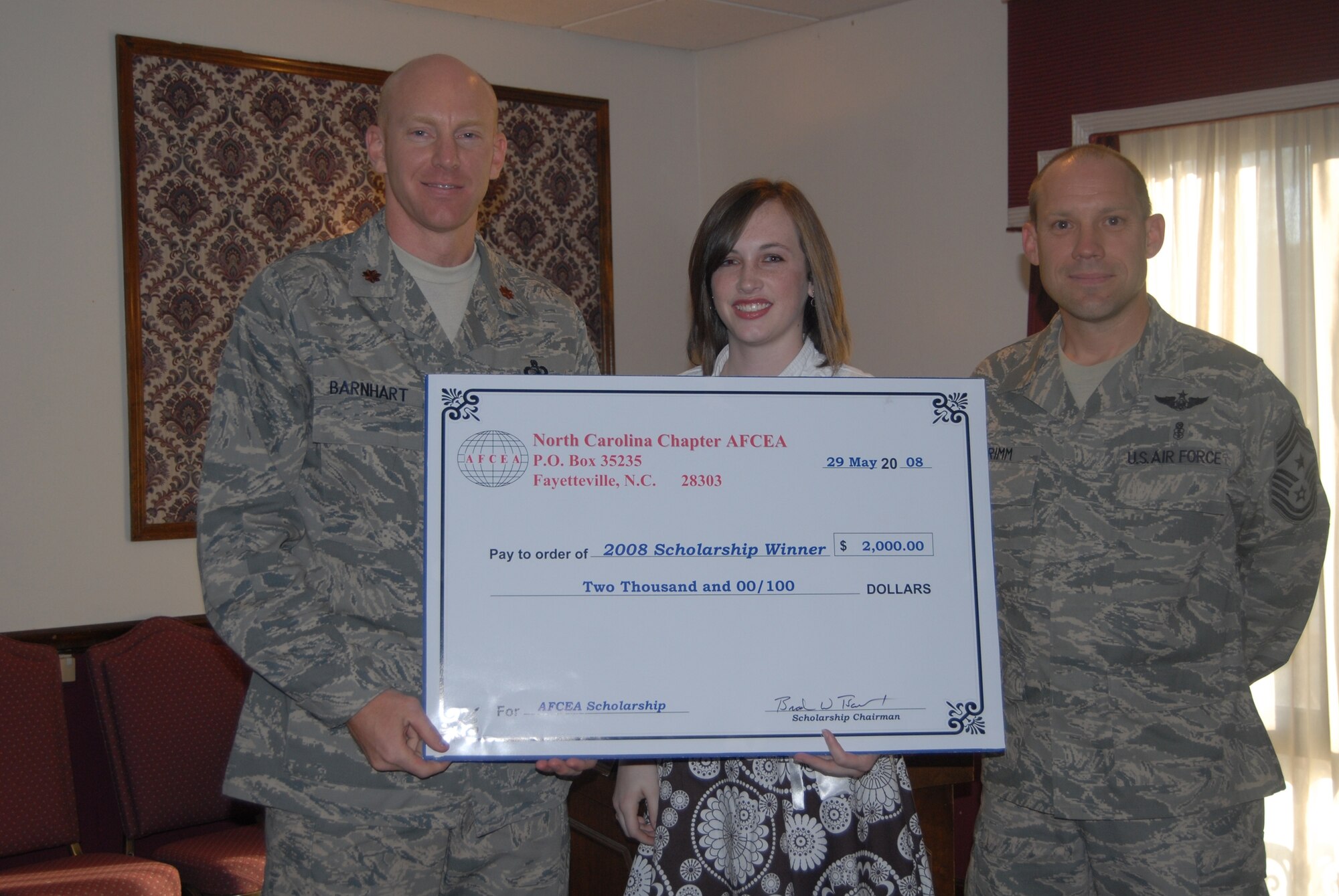 Maj. Brad Barnhart, Commander of Pope’s 43rd Communications Squadron, and 43rd Airlift Wing Command Chief Master Sgt. Michael Grimm, present a scholarship check for $2,000 to Casey Shutt May 29 at the Fort Bragg Officer’s Club. The scholarships were courtesy of the North Carolina chapter of the Armed Forces Communication and Electronics Association, of which Major Barnhart is the acting president. Casey, who is graduating from Cape Fear High School this June, is the daughter of an Army lieutenant colonel stationed at Fort Bragg and one of 10 scholarship recipients. (U.S. Air Force Photo by Airman 1st Class Mindy Bloem)