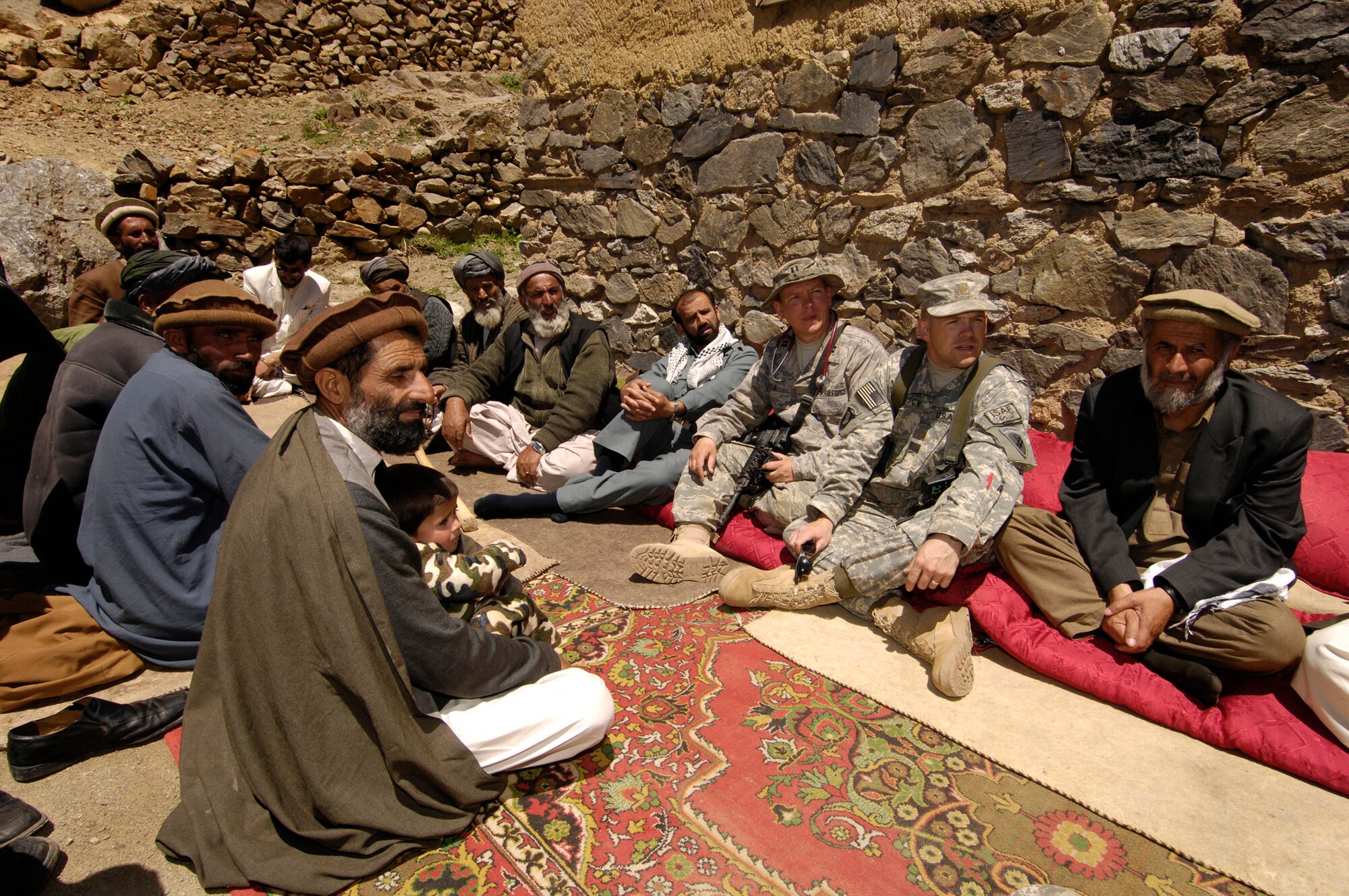 PANJSHIR PROVINCE, Afghanistan - Capt. Glenn Little, Provincial Reconstruction Team chief medical officer (left) and Maj. Nicholas Dickson, Panjshir Reconstruction Team deputy commander, talk to local Afghan elders about a medical engagement here May 29. Captain Little, who is deployed from the 92nd Medical Operations Squadron, Fairchild Air Force Base, Wash., examined more than 40 patients. Major Dickson is deployed from the 451st Civil Affairs Battalion, Pasadena, Texas. The PRT's primary mission is security, governance, reconstruction and developement. (U.S. Air Force photo by Master Sgt. Demetrius Lester)
