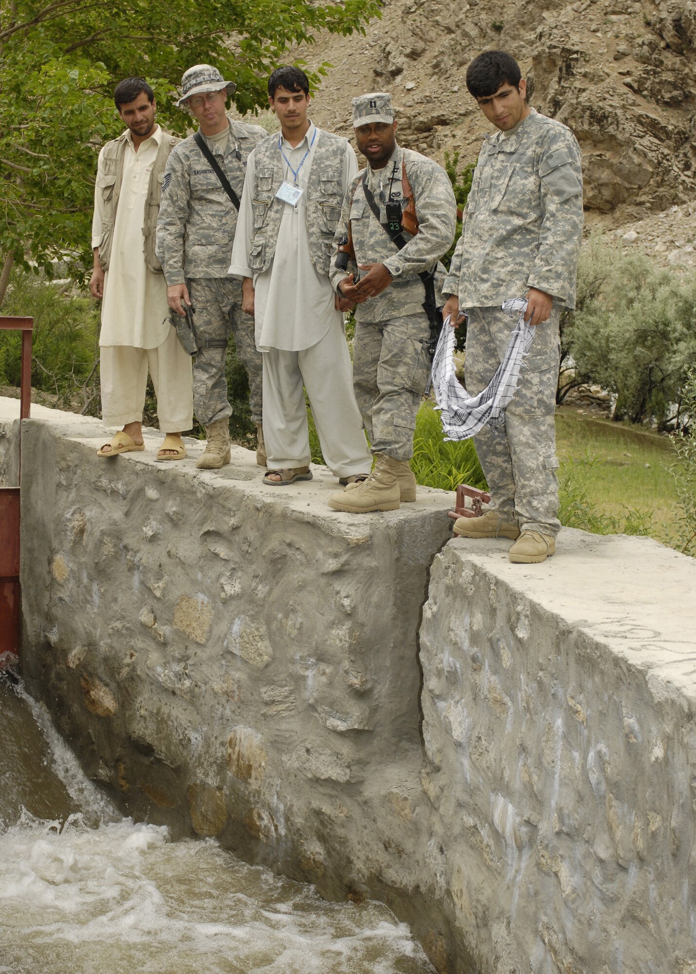 PANJSHIR PROVINCE, Afghanistan - Capt. Kenneth McGinnis (right), Provicial Reconstruction Team project engineer, and Tech. Sgt. David Saugstad (left), structural engineer, speak to local Afghan contractors about the construction of a micro-hydro system here May 28. The system will provide energy to a local Afghan village. The Panjshir PRT's primary mission is to help reconstruct Afghanistan and build U.S. and Afghan relations. Captain McGinnis is deployed from the 28th Civil Engineer Squadron, Ellsworth Air Force Base, S.D., and Sergeant Saugstad is deployed from the 1st Special Operations Civil Engineer Squadron, Hurlburt Field, Fla. (U.S. Air Force photo by Master Sgt. Demetrius Lester)
