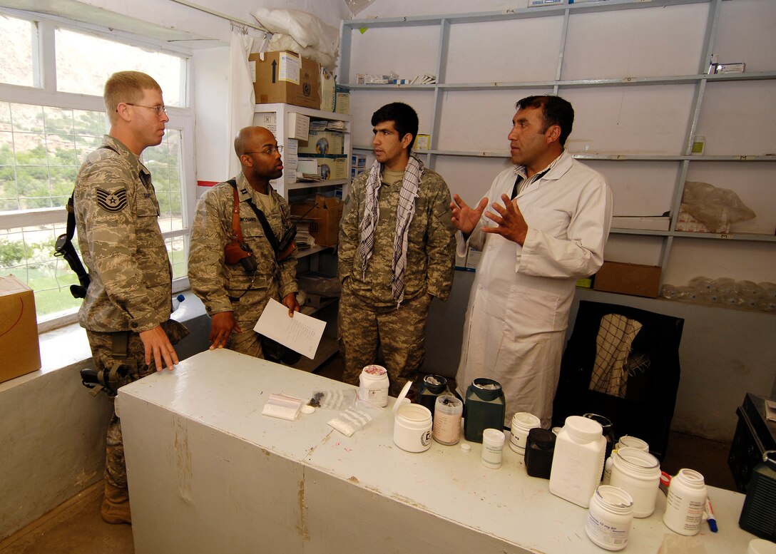 PANJSHIR PROVINCE, Afghanistan -  A local Afghan doctor speaks through an interpreter about building a new medical facility to Capt. Kenneth McGinnis, Provicial Reconstruction Team project engineer, and Tech. Sgt. David Saugstad Provincial Reconstruction Team structural engineer, in the hospital's pharmacy May 28. The Panjshir PRT's primary mission is to help reconstruct Afghanistan and build U.S. and Afghan relations. Captain McGinnis is deployed from the 28th Civil Engineer Squadron, Ellsworth Air Force Base, S.D., and Sergeant Saugstad is deployed from the 1st Special Operations Civil Engineer Squadron, Hurlburt Field, Fla. (U.S. Air Force photo by Master Sgt. Demetrius Lester)