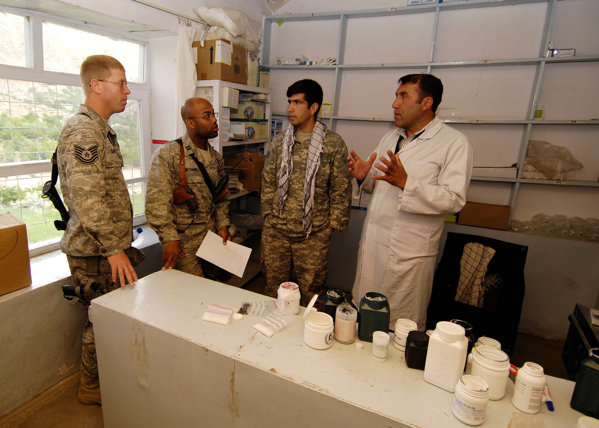 PANJSHIR PROVINCE, Afghanistan -  A local Afghan doctor speaks through an interpreter about building a new medical facility to Capt. Kenneth McGinnis, Provicial Reconstruction Team project engineer, and Tech. Sgt. David Saugstad Provincial Reconstruction Team structural engineer, in the hospital's pharmacy May 28. The Panjshir PRT's primary mission is to help reconstruct Afghanistan and build U.S. and Afghan relations. Captain McGinnis is deployed from the 28th Civil Engineer Squadron, Ellsworth Air Force Base, S.D., and Sergeant Saugstad is deployed from the 1st Special Operations Civil Engineer Squadron, Hurlburt Field, Fla. (U.S. Air Force photo by Master Sgt. Demetrius Lester)