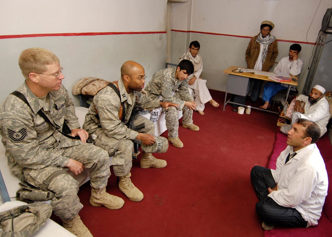 PANJSHIR PROVINCE, Afghanistan - Capt. Kenneth McGinnis (right) Provicial Reconstruction Team project engineer, and Tech. Sgt. David Saugstad (left) Provincial Reconstruction Team structural engineer, speak to local Afghan doctors about building a new medical facility in the hospital's emergency room May 28. The Panjshir PRT's primary mission is to help reconstruct Afghanistan and build U.S. and Afghan relations. Captain McGinnis is deployed from the 28th Civil Engineer Squadron, Ellsworth Air Force Base, S.D., and Sergeant Saugstad is deployed from the 1st Special Operations Civil Engineer Squadron, Hurlburt Field, Fla. (U.S. Air Force photo by Master Sgt. Demetrius Lester)