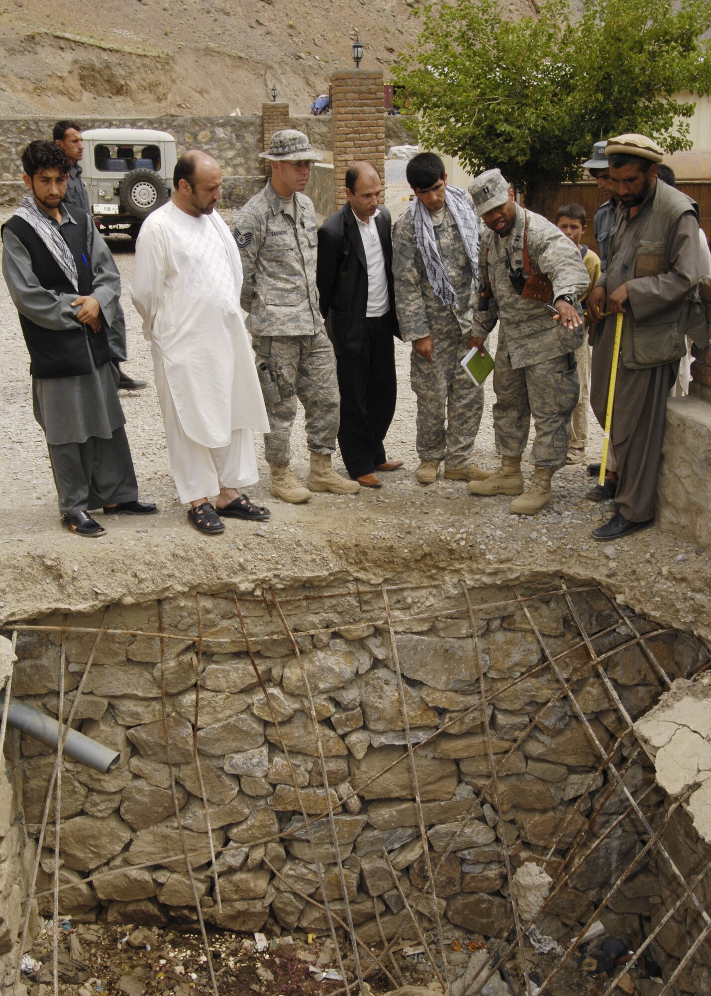 PANJSHIR PROVINCE, Afghanistan - Capt. Kenneth McGinnis (right) Provicial Reconstruction Team project engineer, and Tech. Sgt. David Saugstad (left) Provincial Reconstruction Team structural engineer, speaks to locals through an interpreter (middle) about building a new septic system in the district center of Shutol District May 28. The Panjshir PRT's primary mission is to help reconstruct Afghanistan and build U.S. and Afghan relations. Captain McGinnis is deployed from the 28th Civil Engineer Squadron, Ellsworth Air Force Base, S.D., and Sergeant Saugstad is deployed from the 1st Special Operations Civil Engineer Squadron, Hurlburt Field, Fla. (U.S. Air Force photo by Master Sgt. Demetrius Lester)