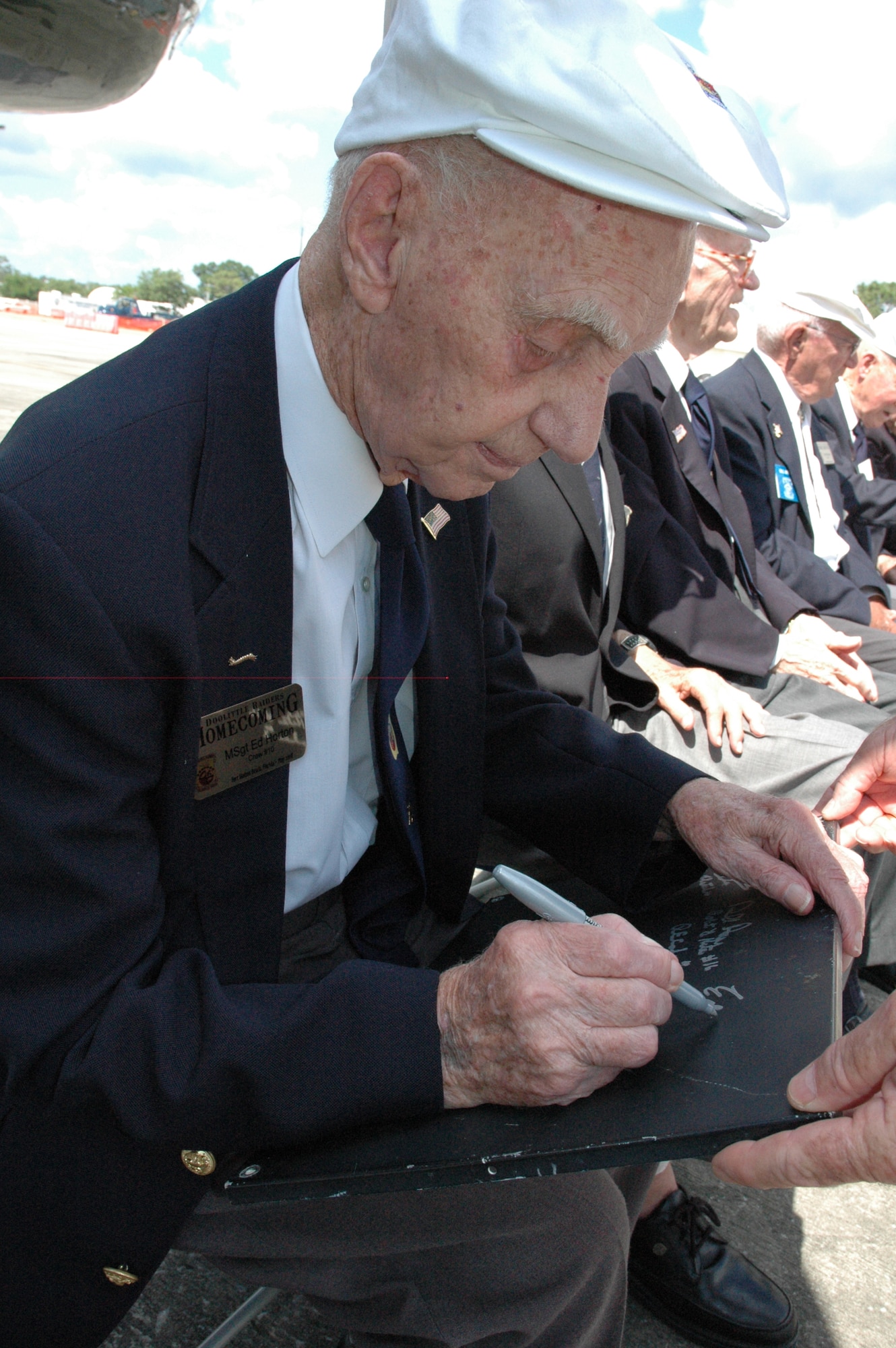 EGLIN AIR FORCE BASE, Fla. -- Retired Master Sgt. Ed Horton, Doolittle Raider from Crew 10, signs a peice of the Special Delivery, a personally-owned B-25 Mitchell. Sergeant Horton flew to Duke Field for the Doolittle Raider Homecoming May 31 in the Special Delivery. (U.S. Air Force/Staff Sgt. Stacia Zachary)