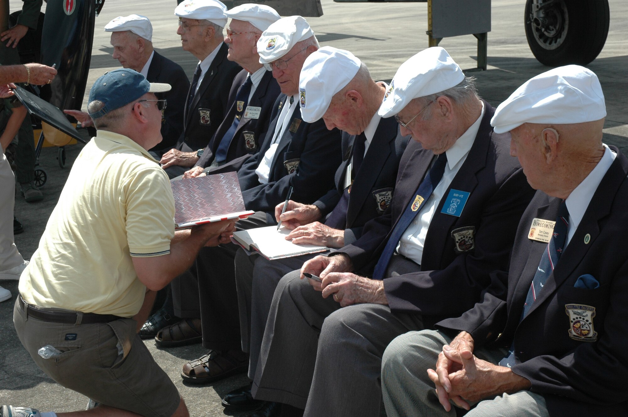Members of the Doolittle Raiders sign autographs during the Doolittle Raiders Homecoming re-enactment May 31 at Duke Field, Fla. The Doolittle Raid, planned by Lt. Col. James "Jimmy" Doolittle, was the first air raid by the United States to strike Japan in World War II and was carried out in retaliation for Japan's attack on Pearl Harbor Dec. 7, 1941. Sixteen B-5 Mitchells took off from an aircraft carrier, a first for the airframe, and bombed military targets in Japan. All 16 aircraft were lost when their crews had to ditch or bail out over China when they ran out of fuel. There are only 11 out of 80 original crewmembers alive today. (U.S. Air Force Photo/Airman 1st Class James P. Brock III)