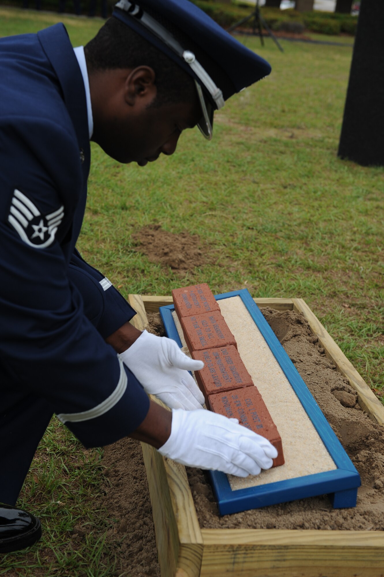 SHAW AIR FORCE BASE, S.C.— Staff Sgt. Raymond Harris, 20th Services Squadron honor guard flight sergeant, lays an engraved brick as part of the ground breaking ceremony for the 9th Air Force and U.S. Air Force Central Airman’s Memorial, May 30. The memorial will honor those military members who have fallen or have served or are currently serving since the inception of 9th AF, June 28, 1942. (U.S. Air Force Photo/Staff Sgt. Henry Hoegen)