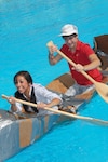 Members of Randolph High School?s physics classes, Ericka Guillen and Tyler Williamson, maneuver their cardboard boat, the SS Minnow, during races that were part of a class project at the center pool Wednesday. Karin Dentino, physics teacher, and other Randolph High personnel supervised the event. (U.S. Air Force photo by Rich McFadden)