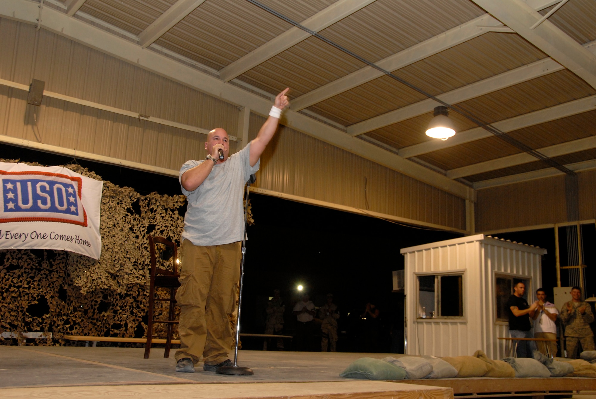 SOUTHWEST ASIA -- Comedian Robert Kelly entertains Airmen deployed to the 386th Air Expeditionary Wing during a comedy show May 30, 2008, at an air base in the Persian Gulf Region. Comedians Al Del Bene, Robert Kelly, and Dane Cook are visiting deployed troops throughout the area of responsibility during a five-day United Service Organizations sponsored Combat Comedy Tour. (U.S. Air Force photo/ Staff Sgt. Patrick Dixon)