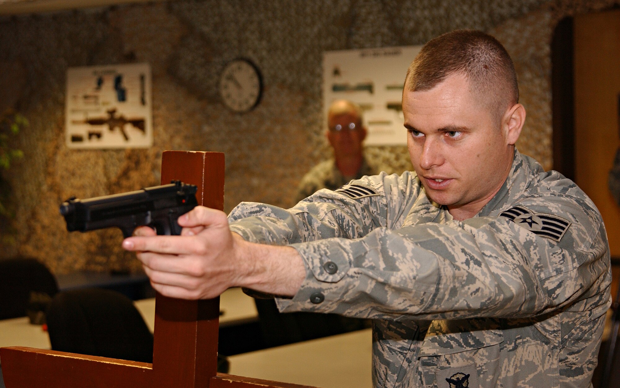Staff Sgt. Keith Corcoran, 39th Security Forces Squadron Combat Arms Training and Maintenance instructor, demonstrates how to fire the M-9 Berretta in the left-side barricaded position during the first CATM class held since the reopening of the range. (U.S. Air Force photo by Airman 1st Class Benjamin WIlson)