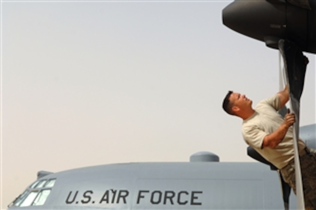 U.S. Air Force Staff Sgt. Jason Giorgini, crew chief of the 332nd Expeditionary Aircraft Maintenance Squadron, examines the intake and propeller of a C-130 Hercules aircraft engine at Balad Air Base, Iraq, on May 19, 2008.  Ensuring the engine is clear of debris is vital to the operability of the engine.  Giorgini is deployed from Little Rock Air Force Base, Ark.  