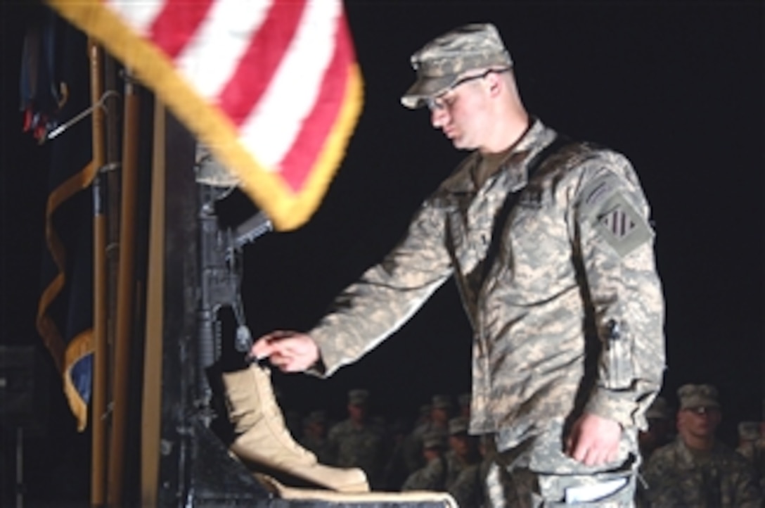 A U.S. soldier pays his respect to a fallen comrade during a memorial service held on Forward Operating Base Iskan, Iraq, May 27, 2008. 