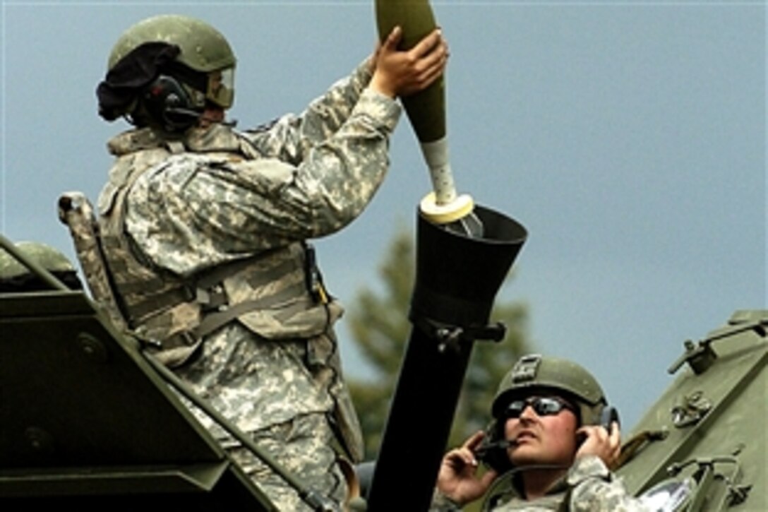 U.S. Army Specialist Allen Cauble, right, watches as U.S. Army Pvt. 2 Shawnee Tapia prepares to fire a 120mm mortar from B-53 during the 8th Squadron, 1st Cavalry Regiment mortar crew's certification, Fort Lewis, Wash., May 30, 2008.