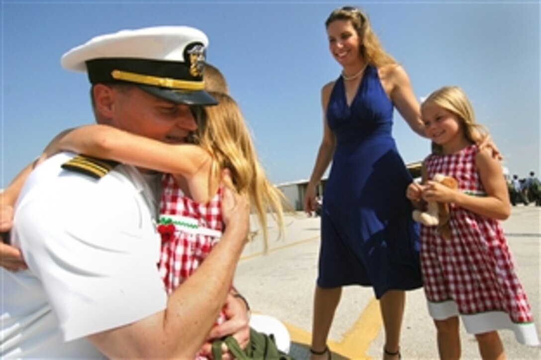 U.S. Navy Lt. Cmdr. Robert Strange, assistant air operations officer aboard the aircraft carrier USS Harry S. Truman, is welcomed home by  his wife and family, Mayport, Fla., June 1, 2008. 
