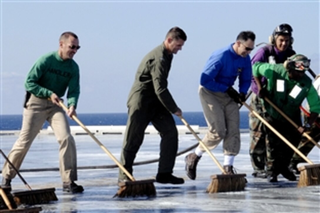 U.S. Navy Lt. Cmdr. Jeffery Sandin, left, ship's handler, Capt. Andrew Lewis, deputy commander, Carrier Air Wing 3, and Capt. Ronald Reis, executive officer of the aircraft carrier USS Harry S. Truman, participate in the final flight deck scrub exercise, Atlantic Ocean, May 31, 2008. 
The USS Truman and embarked Carrier Air Wing 3 are preparing to return home after a seven-month deployment. 