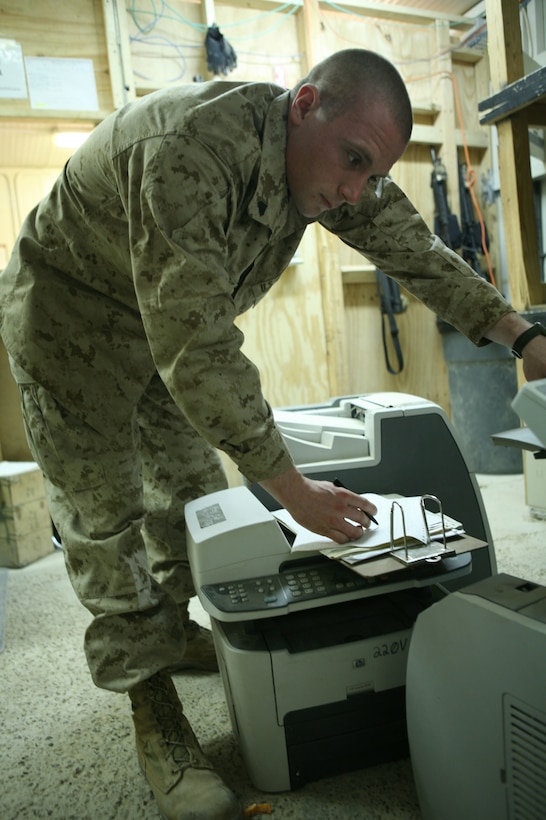Cpl. Joseph A. Walkowiak, a 25-year old clerk from Bay City, Mich., with Communications Platoon, Headquarters Company, Regimental Combat Team 1, inventories and inspects gear inside the communications building at Camp Fallujah June 2. Walkowiak had been out of the Marine Corps for two years and was working for a federal agency when he was recalled.