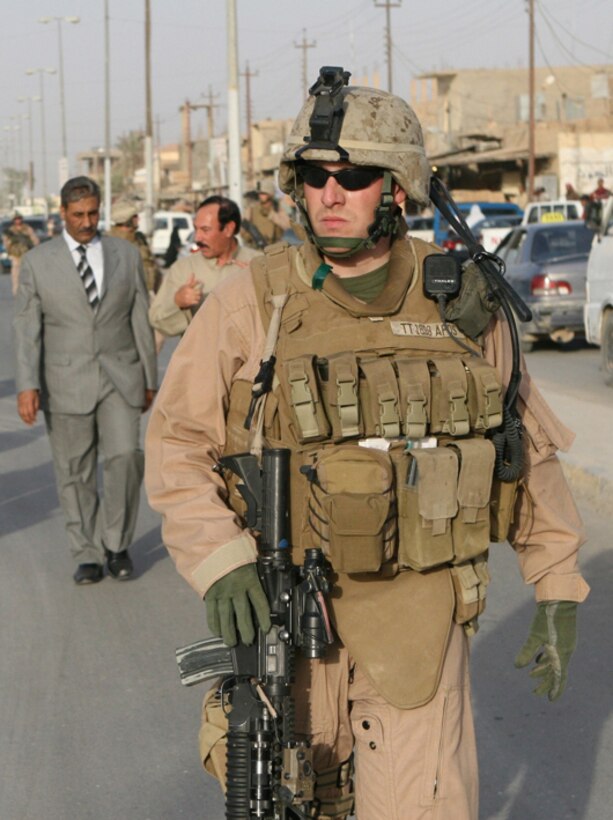 Cpl. Tollin Toler, a rifleman with the Jump Platoon, Task Force 2nd Battalion, 2nd Marines, Regimental Combat Team 5, provides security during a tour of Husaybah, Iraq, June 2. The Mayor of Al Qa'im, Farhan Tekan Farhan escorted Lt. Col. Steven J. Grass, the battalion commander, TF 2nd Bn., 2nd Marines, through the community to show him local stores and greet the townspeople.