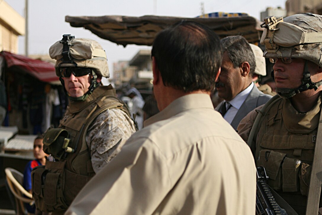 Lt. Col. Steven J. Grass, the battalion commander of Task Force 2nd Battalion, 2nd Marines, Regimental Combat Team 5, walks through the markets of Husaybah, Iraq, June 2. The mayor of Al Qa'im, Farhan Tekan Farhan, led the way through the streets, greeting townspeople and showing Grass the local shops he frequents, including his personal barber.